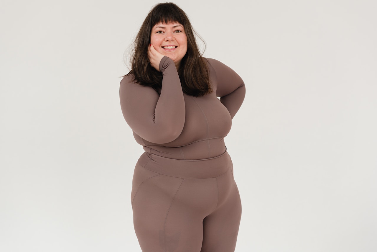A plus-size woman posing and smiling