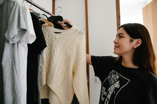 A young woman hanging clothes on a cloth rack
